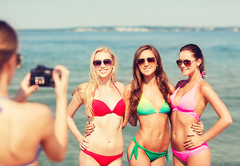 Image showing group of smiling women photographing on beach
