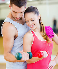 Image showing two smiling people working out with dumbbells