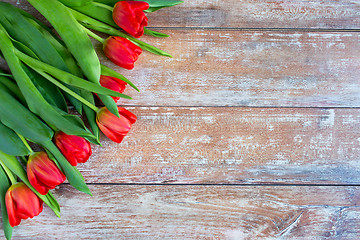 Image showing close up of red tulips on wooden background