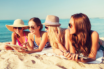 Image showing group of smiling young women with tablets on beach