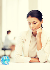 Image showing businesswoman looking at alarm clock