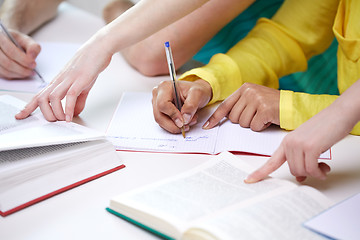 Image showing close up of students hands writing to notebooks