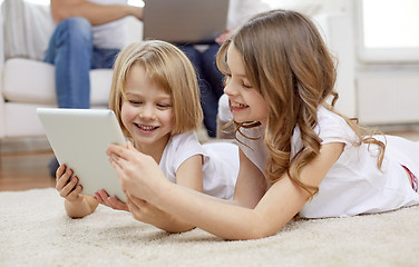 Image showing happy little girls with tablet pc computer at home