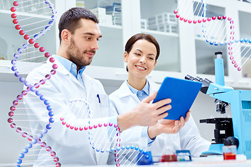 Image showing scientists with tablet pc and microscope in lab