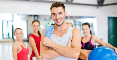 Image showing smiling man standing in front of the group in gym