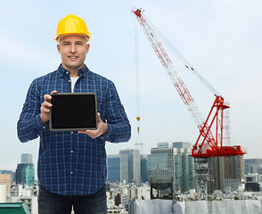 Image showing smiling male builder in helmet with tablet pc