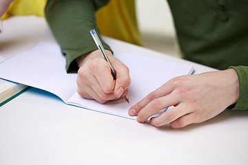 Image showing close up of male hands writing to notebook