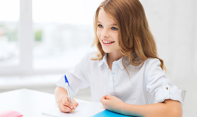 Image showing student girl writing in notebook at school