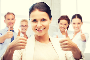 Image showing businesswoman showing thumbs up in office