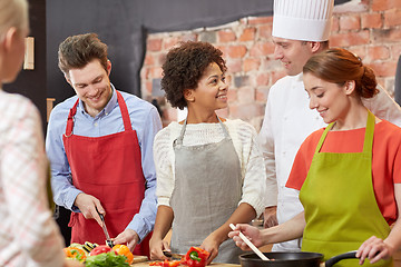 Image showing happy friends and chef cook cooking in kitchen