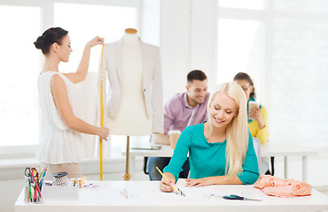 Image showing smiling fashion designers working in office