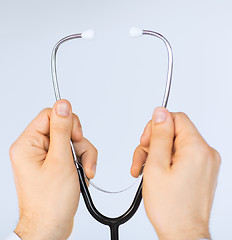 Image showing doctor hand with stethoscope listening something