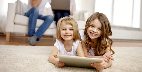 Image showing happy little girls with tablet pc computer at home