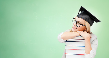 Image showing happy student in mortar board cap with books