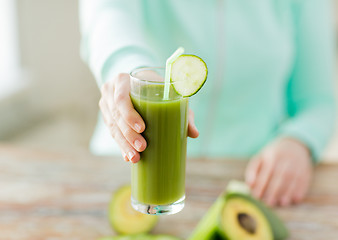 Image showing close up of woman hands with juice and vegetables