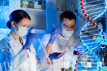 Image showing scientists with pipettes and test tubes in lab