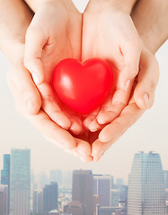 Image showing close up of couple hands holding red heart