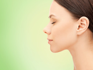 Image showing beautiful young woman face over green background