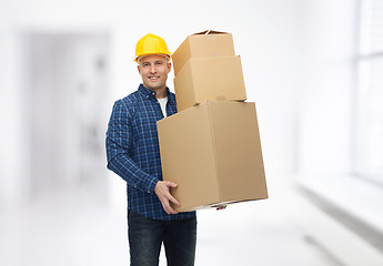 Image showing smiling man in helmet with cardboard boxes