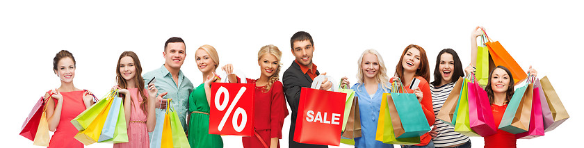 Image showing happy people with sale sign on shopping bags