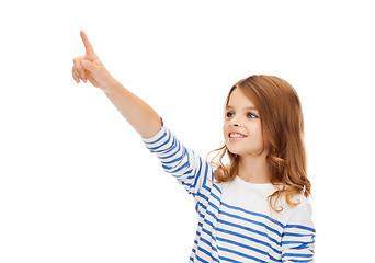 Image showing smiling girl pointing at virtual screen