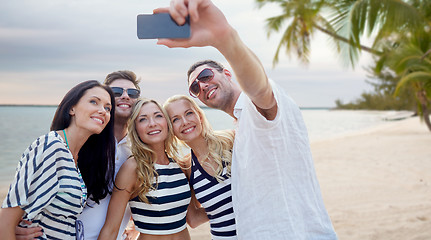Image showing friends on beach taking selfie with smartphone