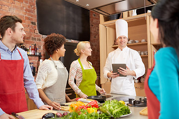 Image showing happy friends with tablet pc in kitchen