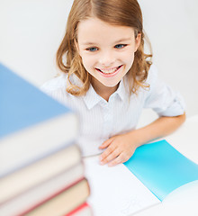 Image showing smiling little student girl with many books