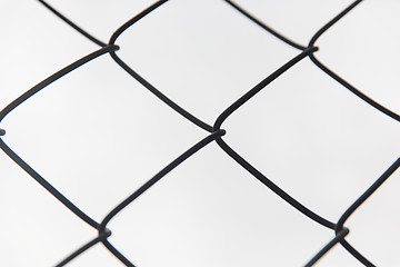 Image showing close up of mesh fence over gray sky