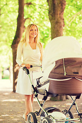 Image showing happy mother with stroller in park