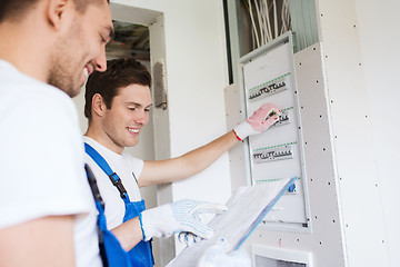 Image showing builders with clipboard and electrical panel