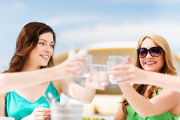 Image showing girls making a toast in cafe on the beach