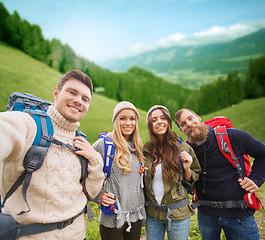 Image showing group of smiling friends with backpacks hiking