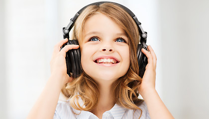 Image showing little girl with headphones at home