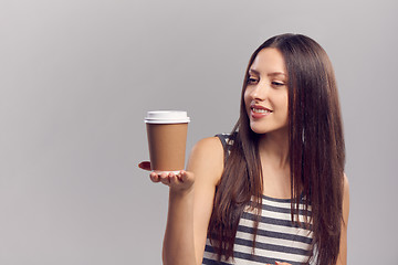 Image showing Woman drinking hot drink from disposable paper cup