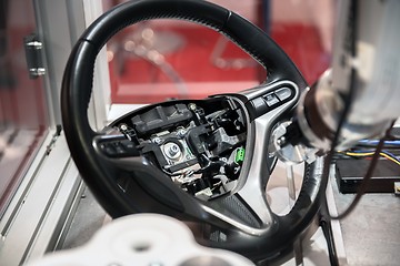 Image showing Robotic arm tearing down steering wheel