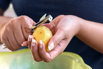 Image showing Potato is peeled with a kitchen knife