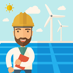 Image showing Man in solar panel and windmills.