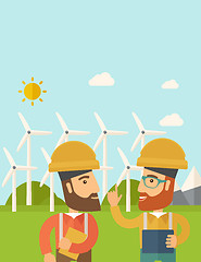 Image showing Two workers talking infront of windmills.