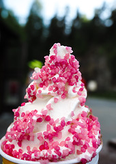 Image showing Closeup of soft serve ice cream with fresh pink frizzle outdoors