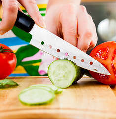 Image showing Woman\'s hands cutting cucumber