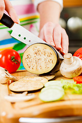 Image showing Woman\'s hands cutting aubergine eggplant