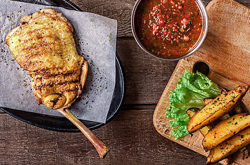 Image showing Fried chicken meat on the bone, potato wedges, lettuce 