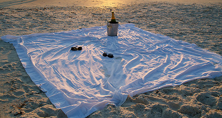 Image showing champagne and sunglasses on the beach at sunset