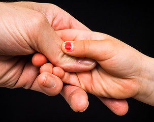 Image showing Daughter connecting with fathers hand isolated towards black