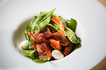 Image showing Salad with strawberry, prosciutto, herbs, cottage cheese and blackberry balsamic vinegar.