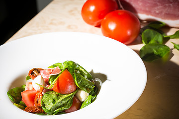 Image showing Salad with strawberry, prosciutto, herbs, cottage cheese and blackberry balsamic vinegar.