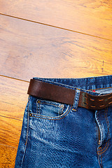 Image showing Aged blue jeans with a leather belt 