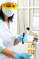 Image showing doctor looking at a test tube of dark solution