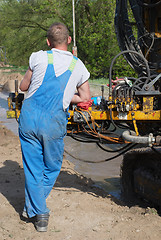 Image showing Workman and machine